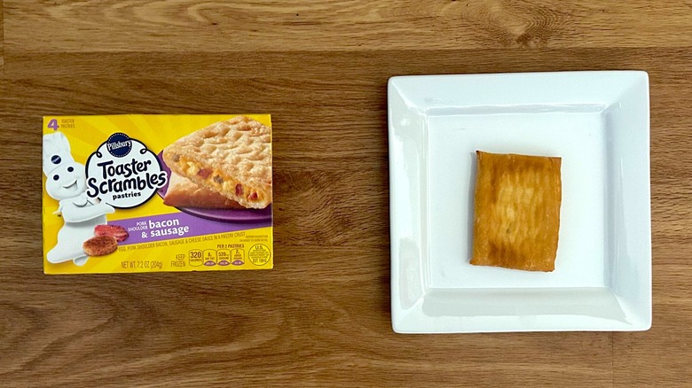 Package and cooked Pillsbury Toaster Scrambles Pastries Bacon & Sausage on square white plate