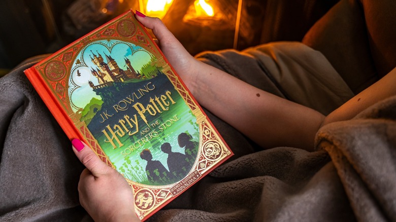 hands hold a copy of a harry potter book