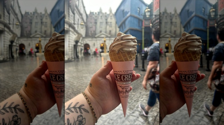 a hand holds a butterbeer ice cream cone