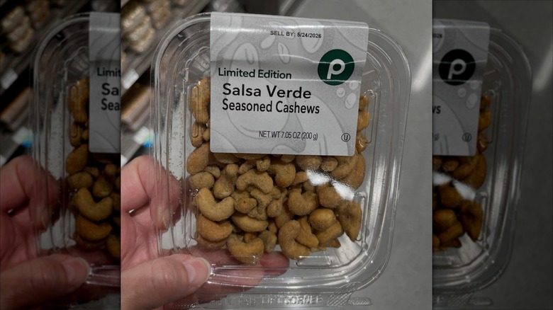 hand holding a package of seasoned cashew nuts
