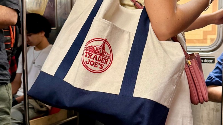 subway passenger holds large trader joe's canvas bag