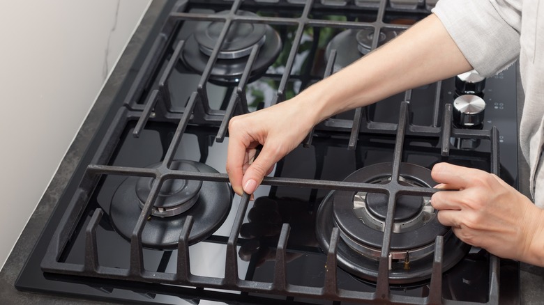 removing a cast-iron stove grate from a gas cooktop