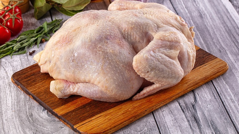 whole chicken on wooden board
