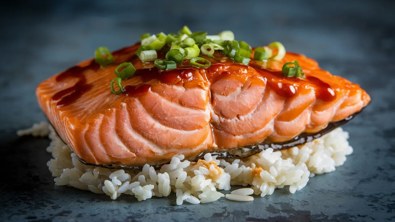 A cooked salmon fillet on a bed of white rice