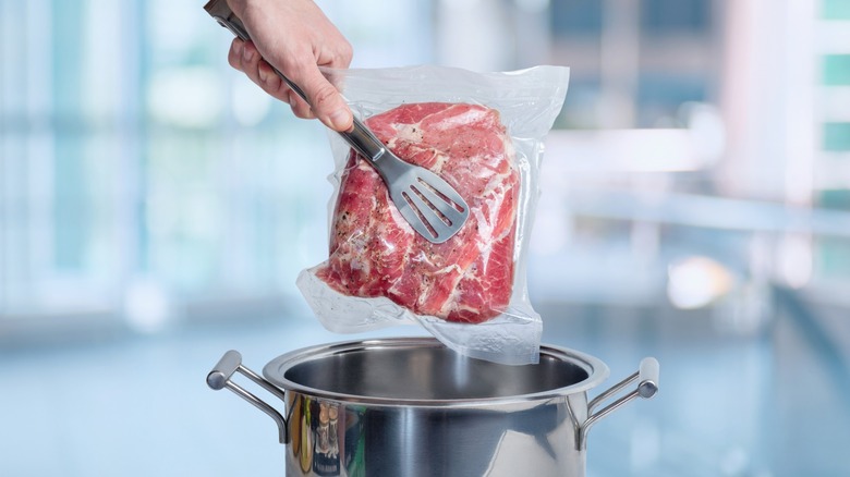dropping vacuum-sealed meat into pan with tongs