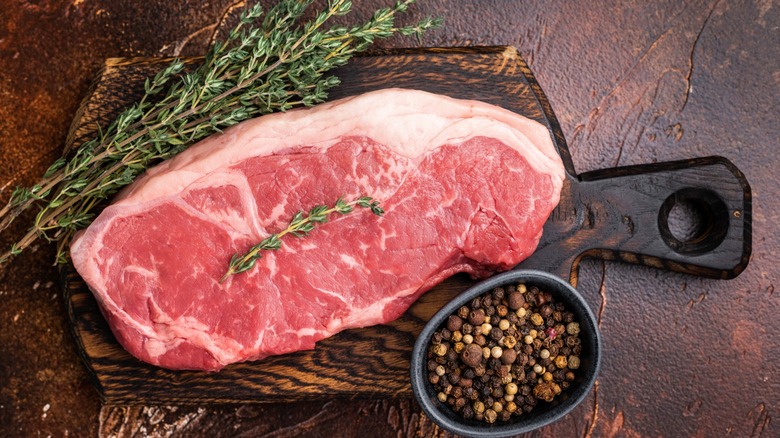 raw steak on a wooden board