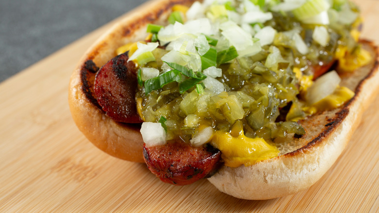 a butterflied hot dog is loaded with toppings