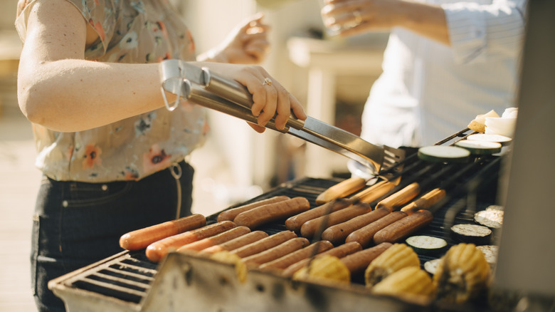 grilling hot dogs with tongs