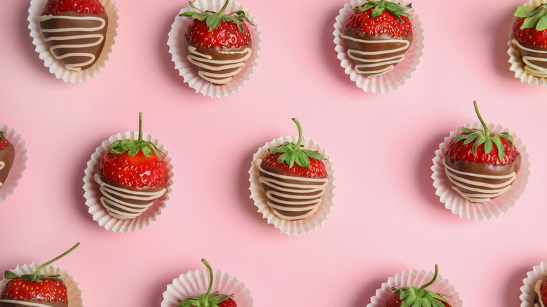 chocolate-covered strawberries in repeating pattern on a pink background