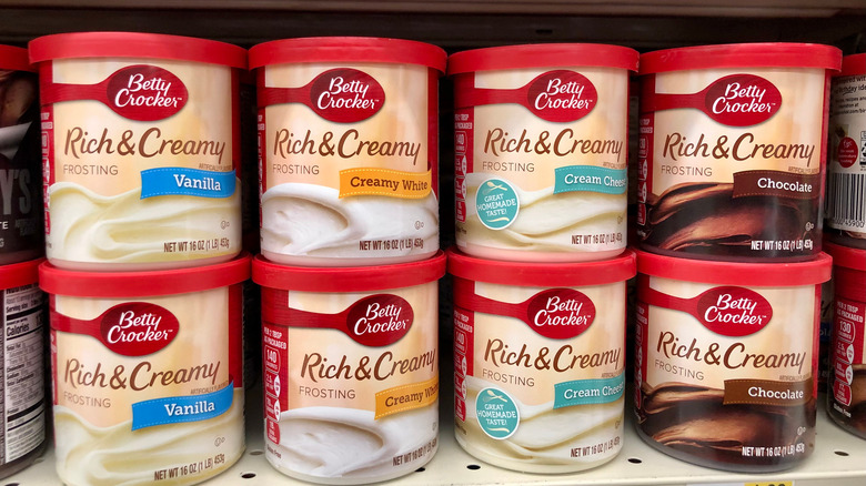 Cans of store-bought frosting on grocery shelf