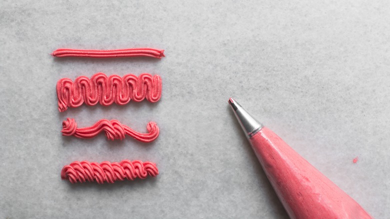 piping bag with pink frosting shapes