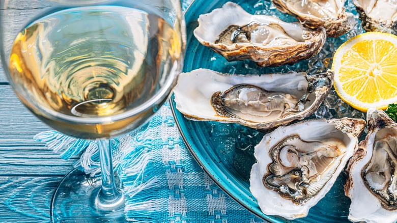 Oysters and glasses of wine on table