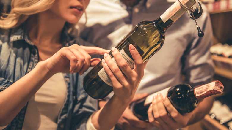 Two people choosing wine in the wine store.