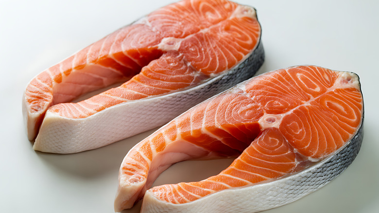 Two fillets of salmon on a white background