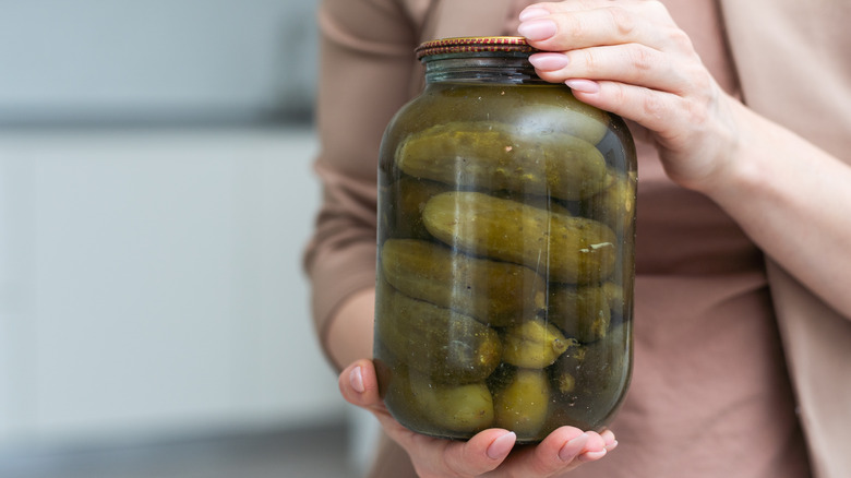 Someone holding an unlabeled jar of pickles with both hands