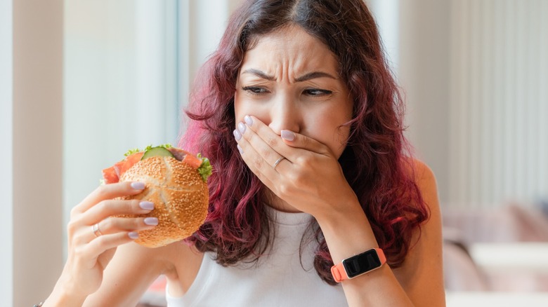 young person not enjoying her sandwich in cafe