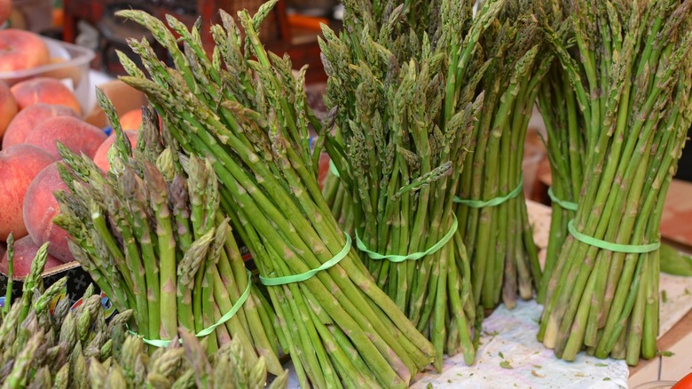 Bunches of asparagus in table with white cloth