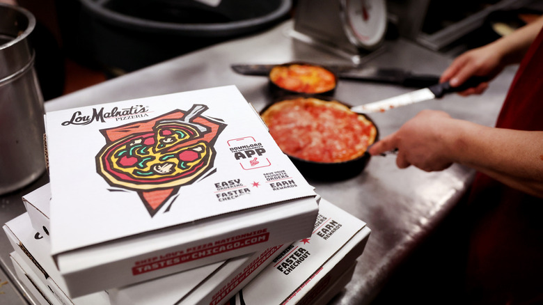 In the kitchen at a Lou Malnati's location showing the pizza box and deep dish pizza.