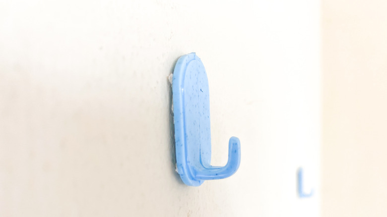 A close-up of a blue wall-mounted plastic hook