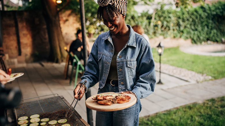 Woman preparing a barbecue in the back yard