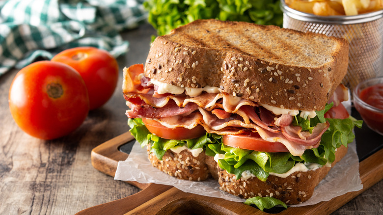 BLT sandwich on wooden board.