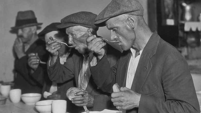 men eat soup at counter during the great depression