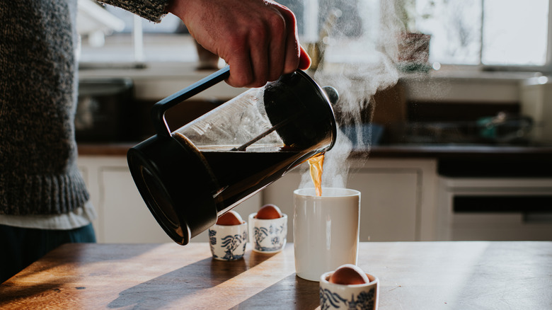 Someone pouring a cup of hot coffee