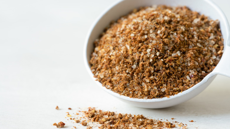 cajun seasoning spilling from measuring cup