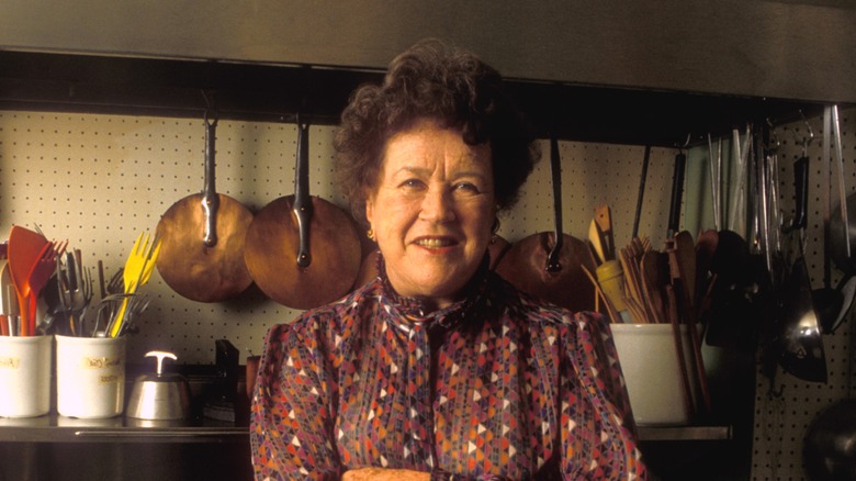Julia Child standing in kitchen with arms crossed