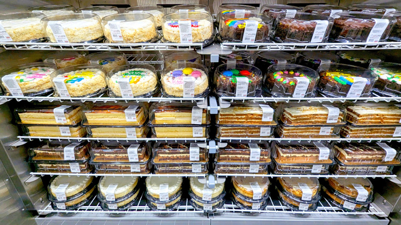 Costco cakes and other desserts layered on refrigerated shelves