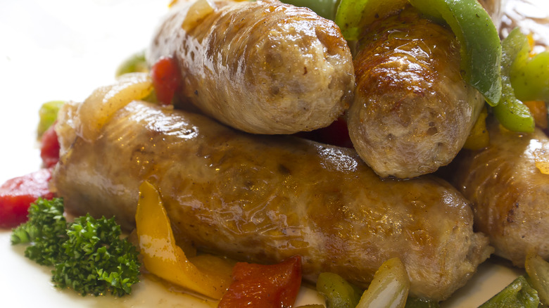 Italian sausages with peppers and onions on white background