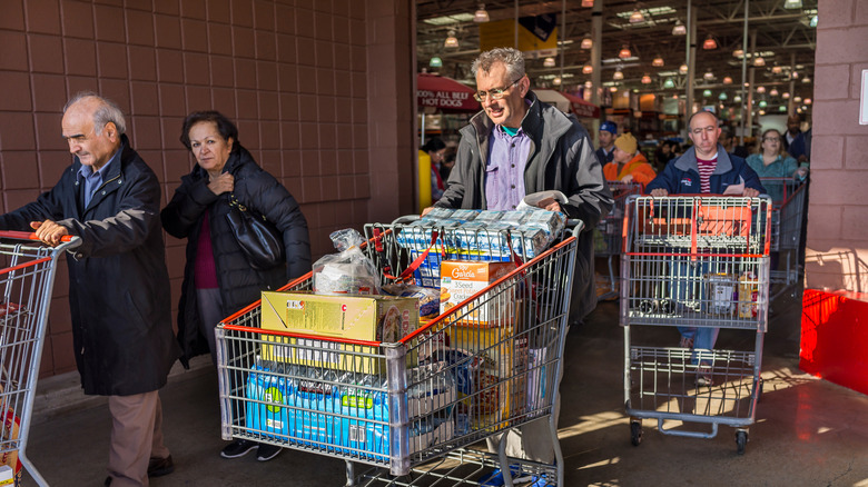 customers push shopping carts out of costco