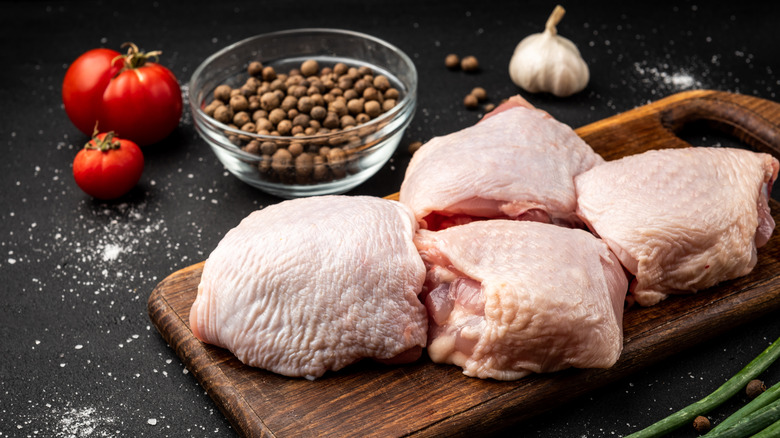 four chicken thighs laid out on cutting board