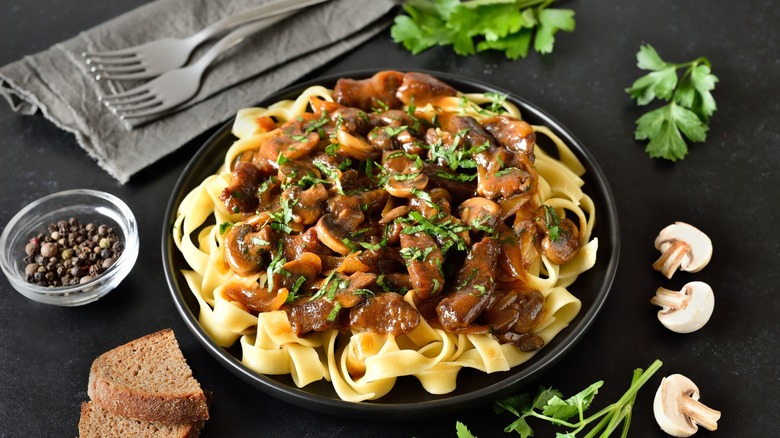 beef stroganoff in bowl with black surface