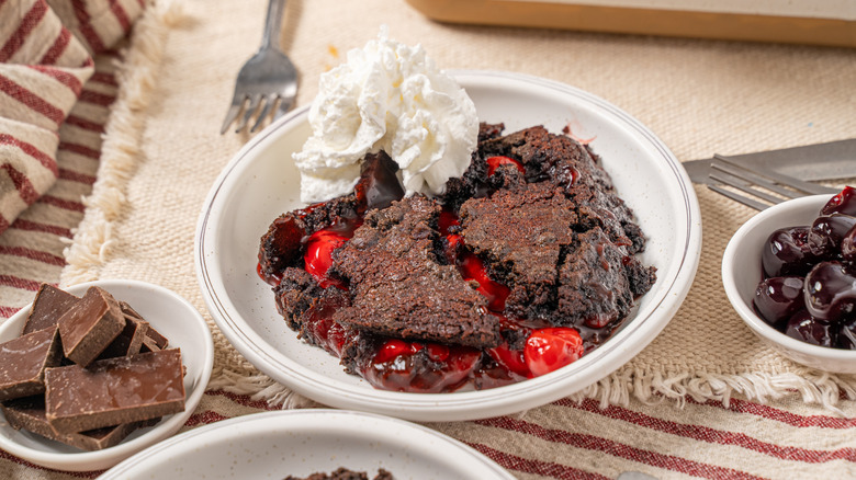 Bowl of chocolate cherry dump cake with whipped cream