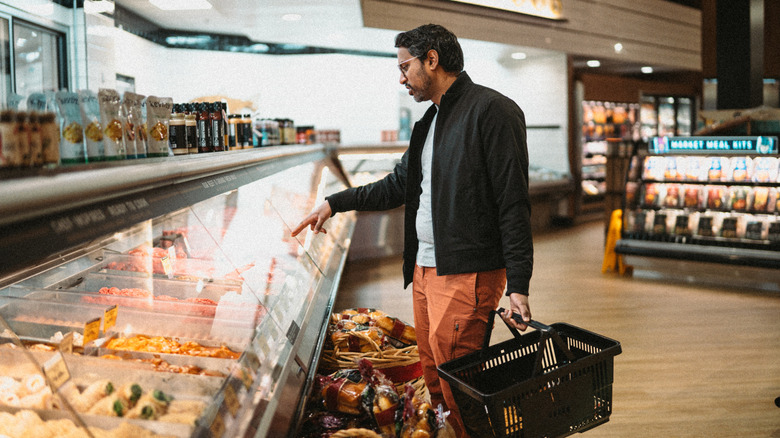 Man ordering from deli counter at a grocery store