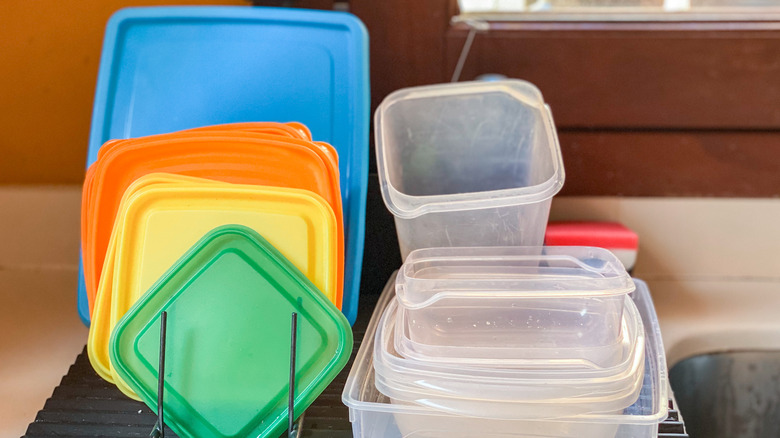tupperware and lids on drying rack by sink