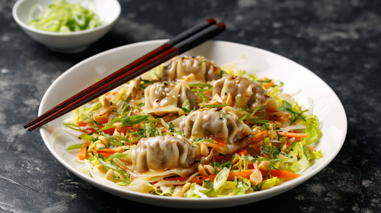 gyoza-topped salad in a bowl.