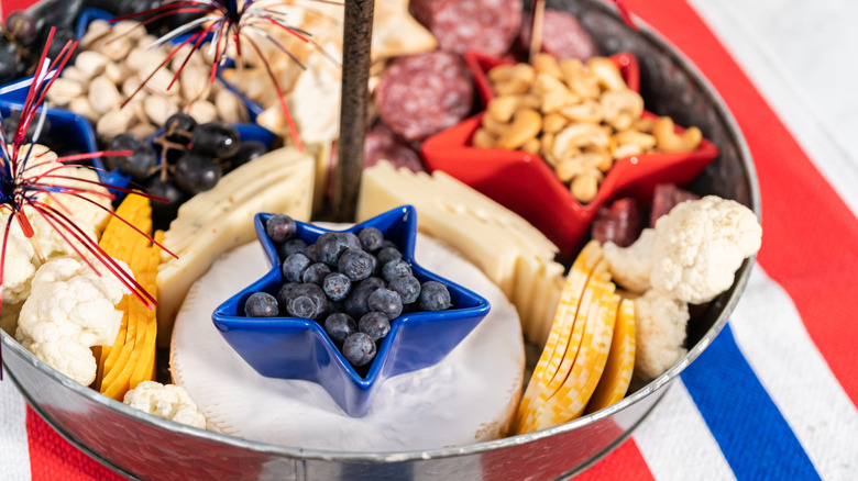 Charcuterie board with various red, white, and blue ingredients