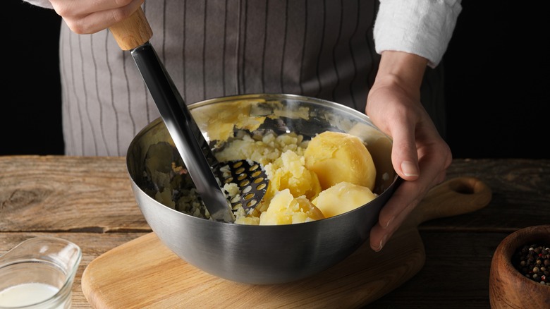 mashing potatoes in a bowl