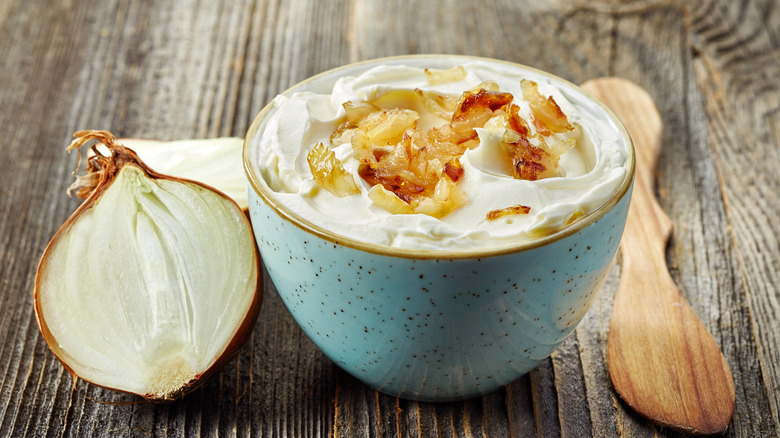 bowl of onion dip next to onion sliced in half