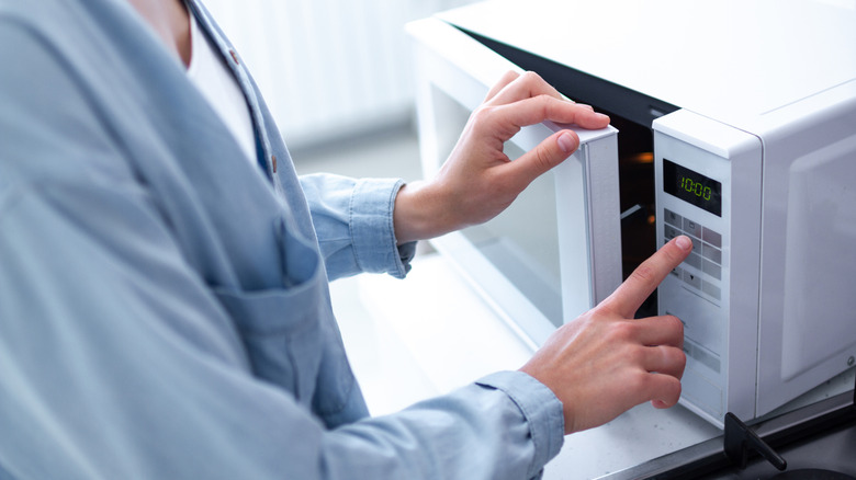 Person using microwave.