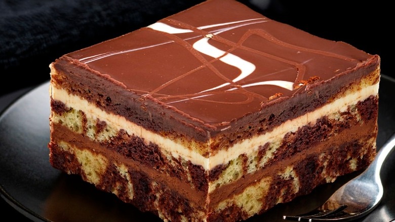 Slice of tuxedo mousse layer cake on black background