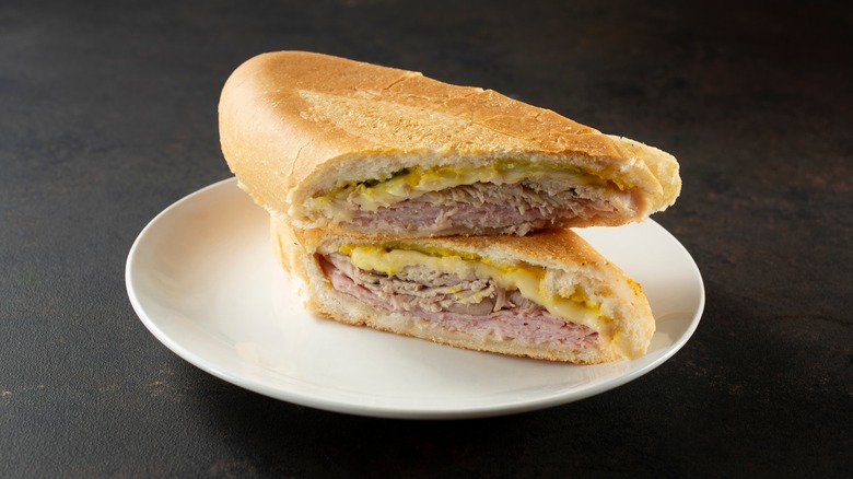 halved cuban sandwich on white plate