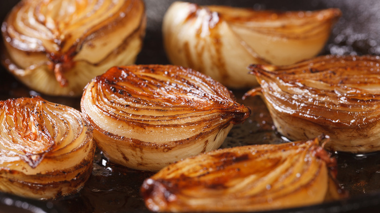 Caramelized onion halves in a pan