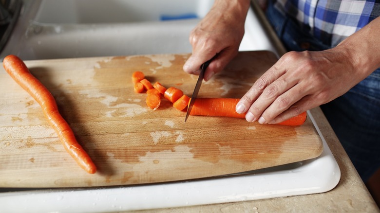 a wooden cutting board fits over a sink