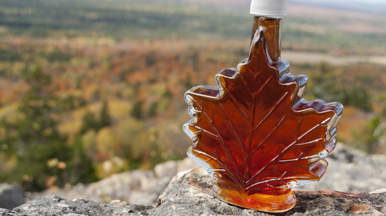Leaf-shaped glass bottle of maple syrup