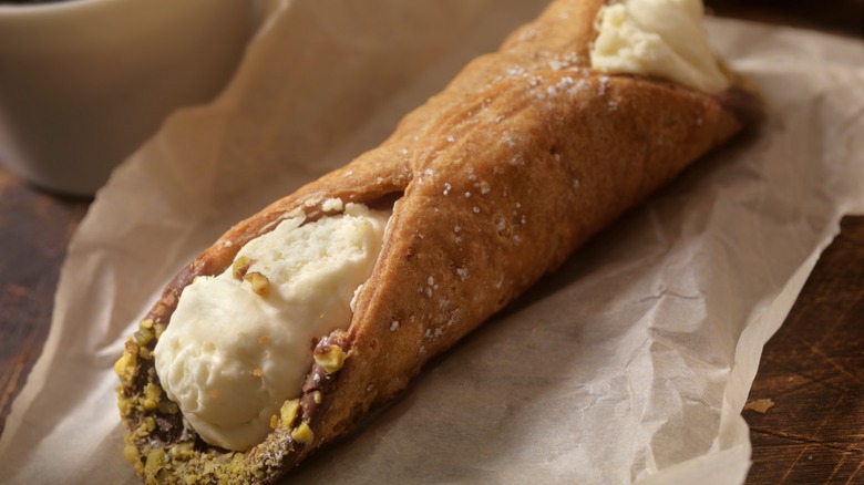 cannolo on brown paper with chocolate and nuts