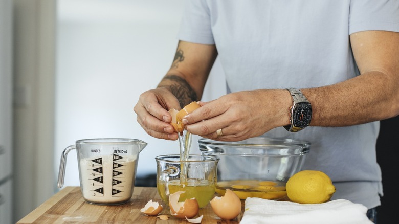 man preps french toast ingredients on counter