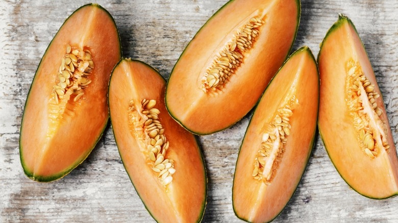 cut cantaloupe on wooden surface
